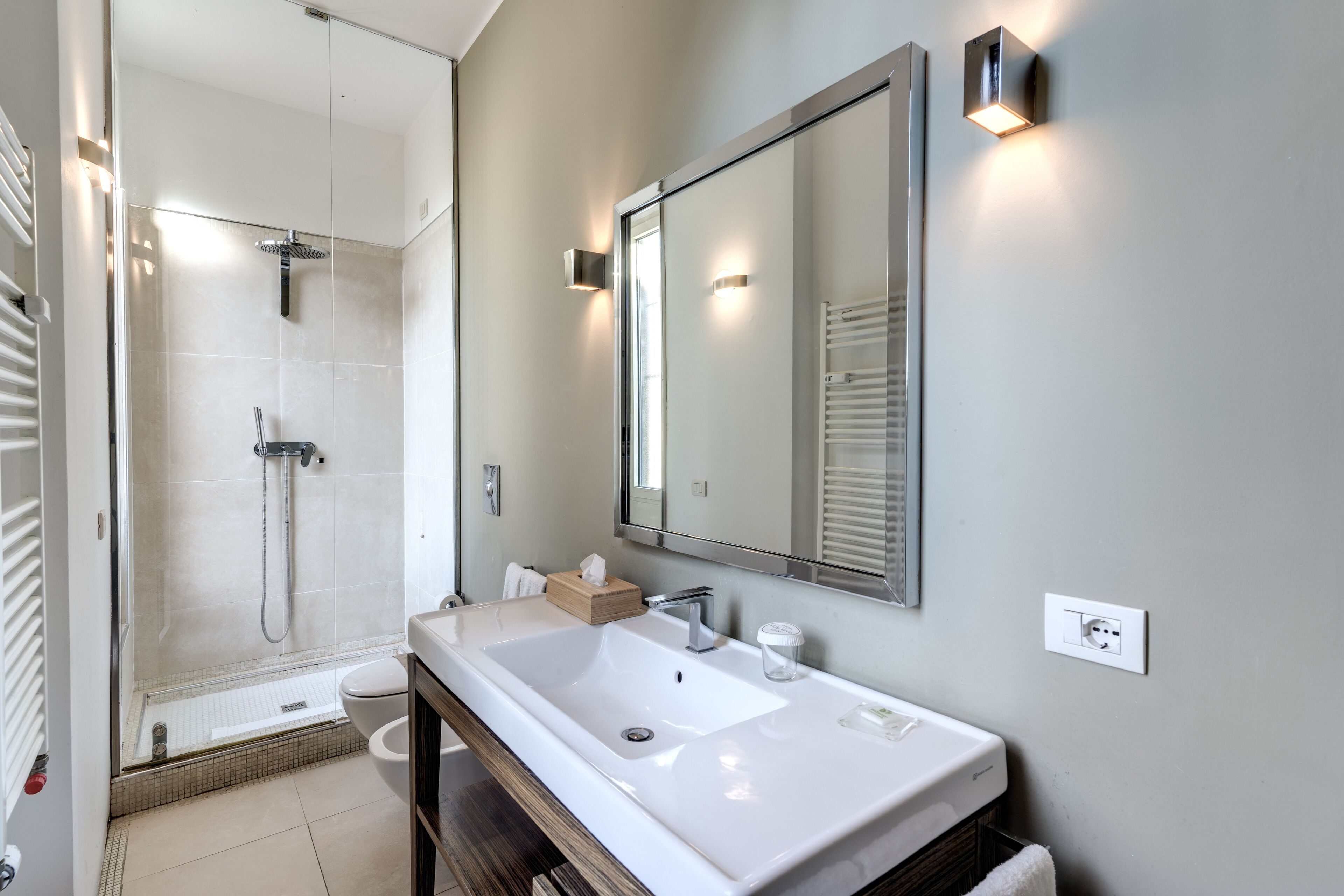 Un baño moderno con un lavamanos grande, un espejo y una ducha.