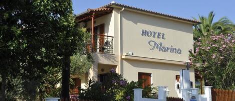 A two-story building with a sign reading "HOTEL Marina."