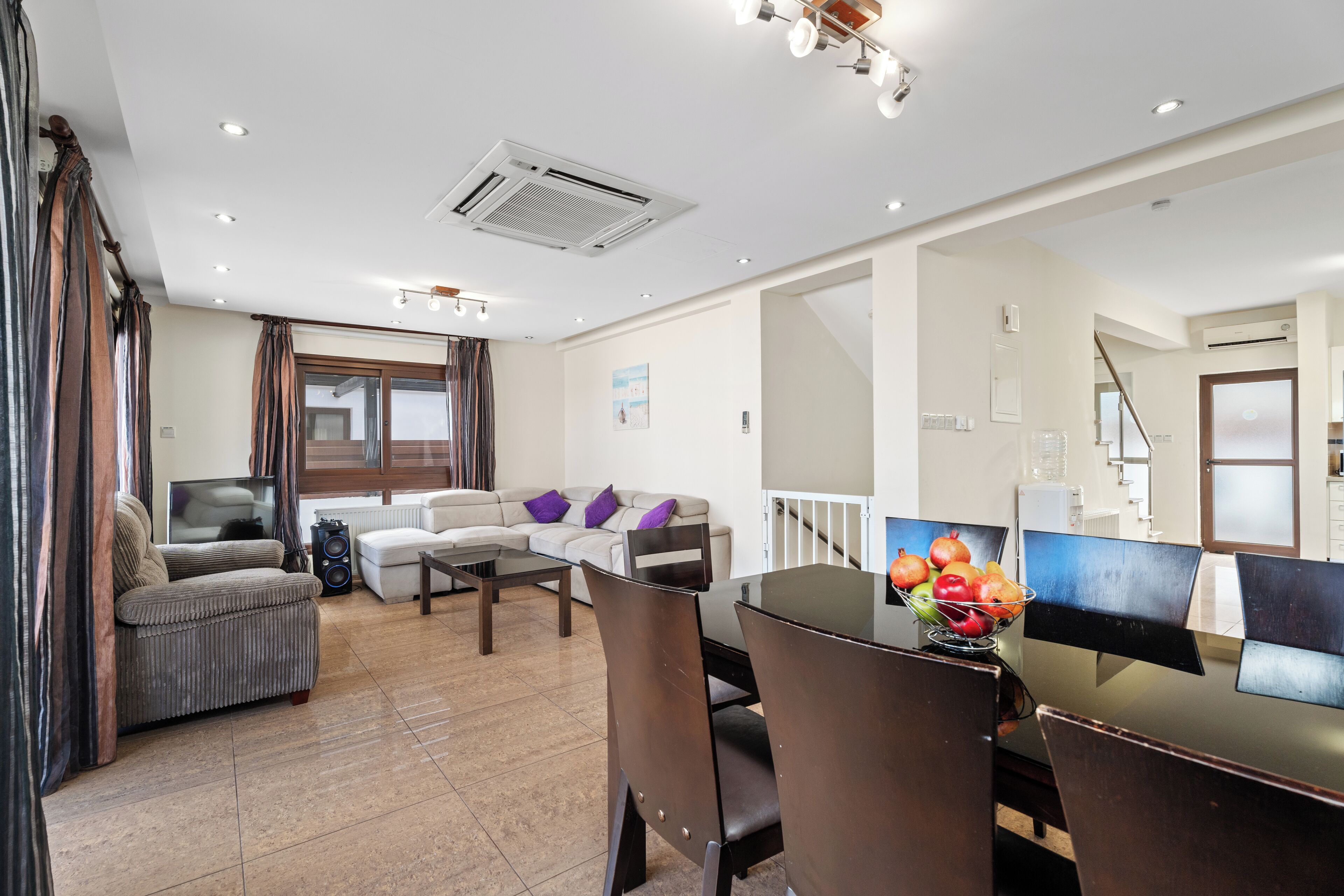 Un salon moderne comprenant un canapé, une table basse et un coin repas avec des chaises et une table.