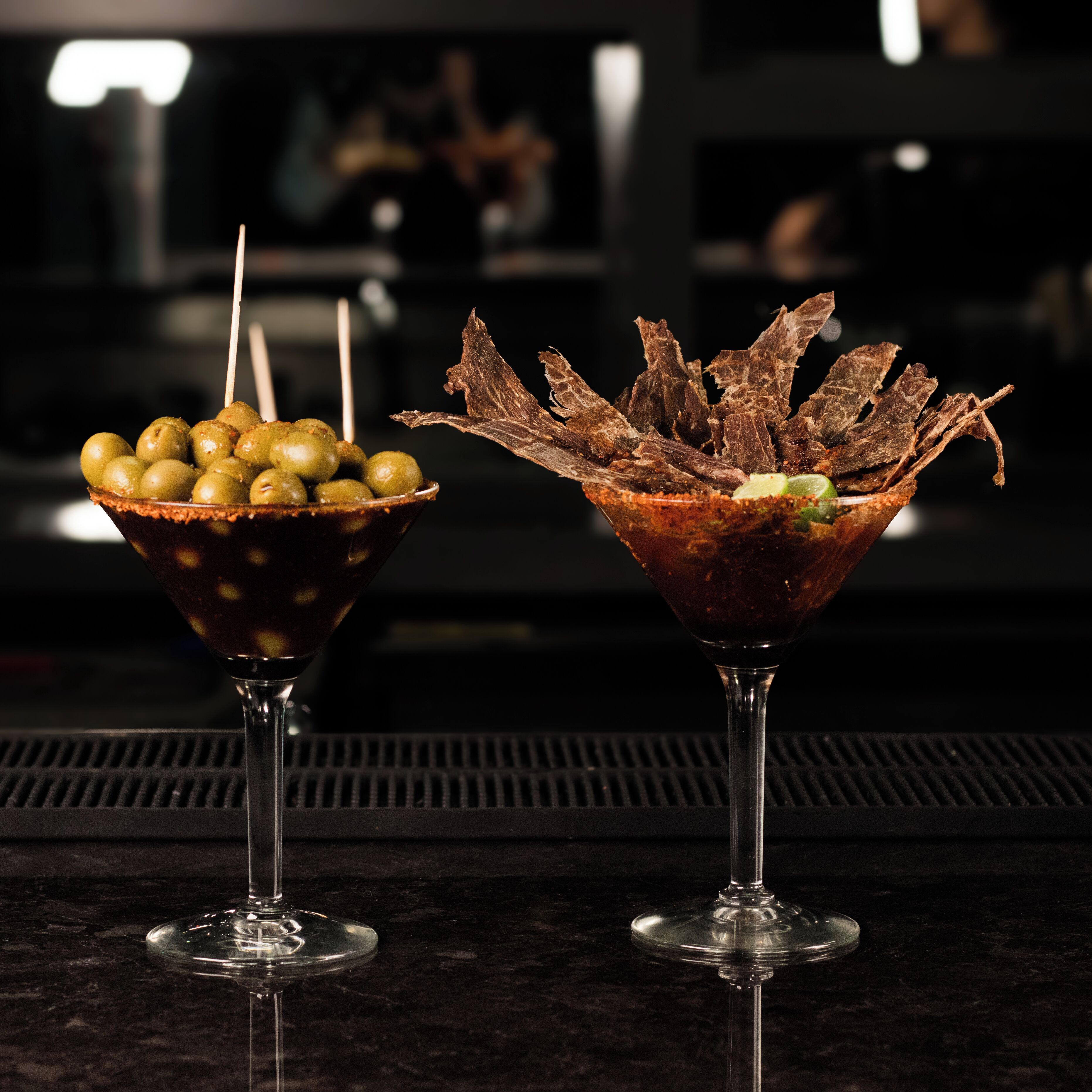 Deux verres à martini sur le comptoir d’un bar.