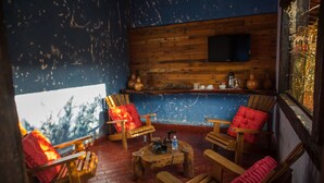 Une pièce chaleureuse, meublée en bois, avec une cheminée et un téléviseur fix é au mur.