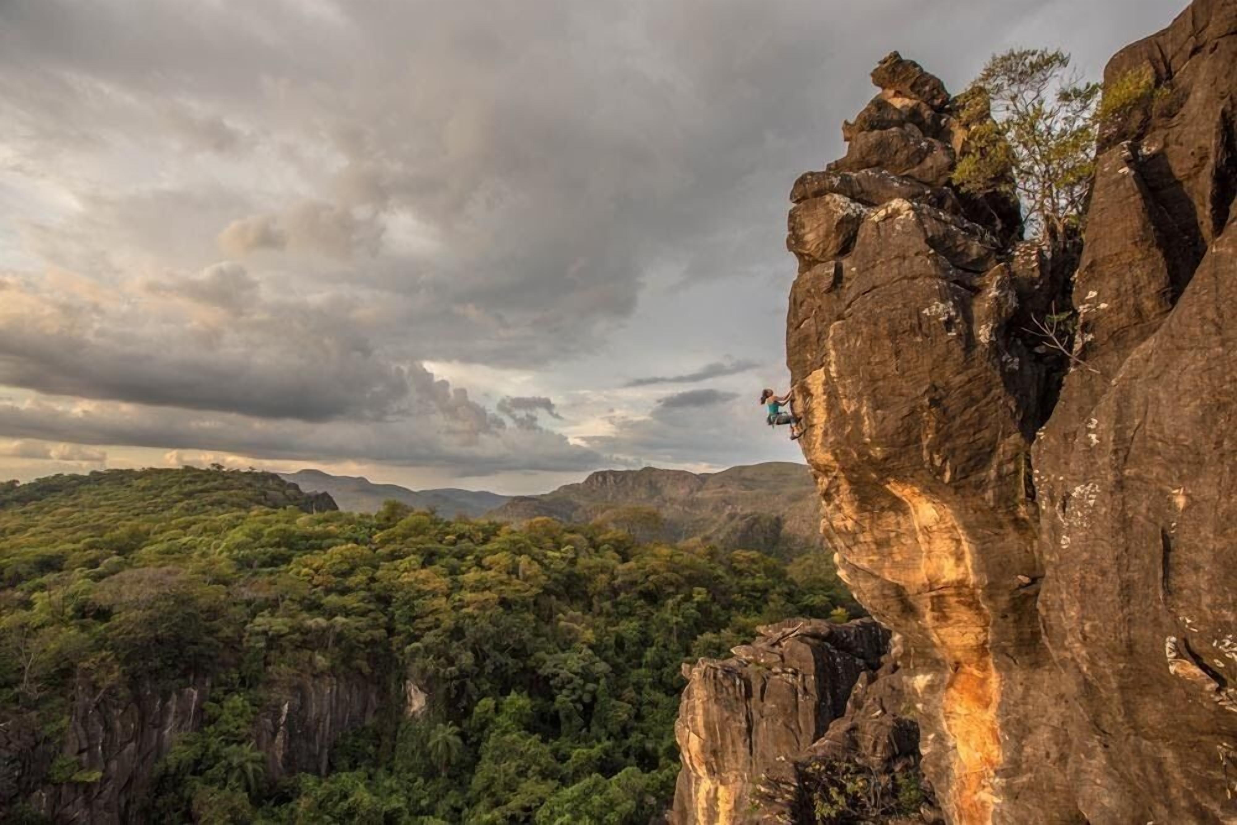A rugged cliff with a person climbing.