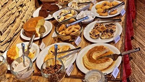 Una mesa de buffet con diversos alimentos y utensilios.