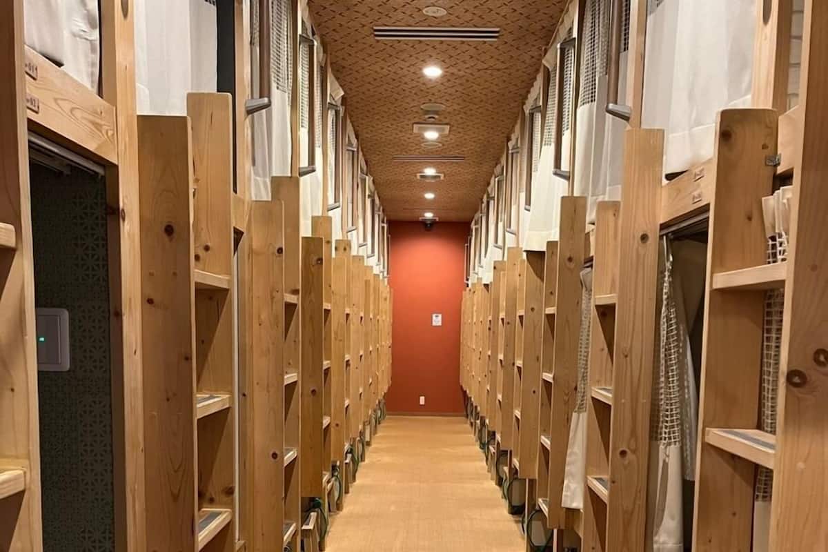 A row of wooden lockers with a patterned ceiling and a carpeted floor.