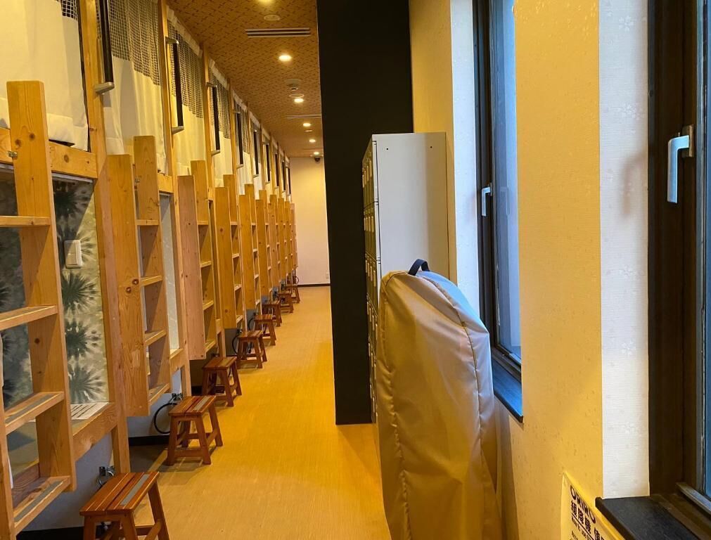 A corridor with wooden benches, a covered area, and a window.
