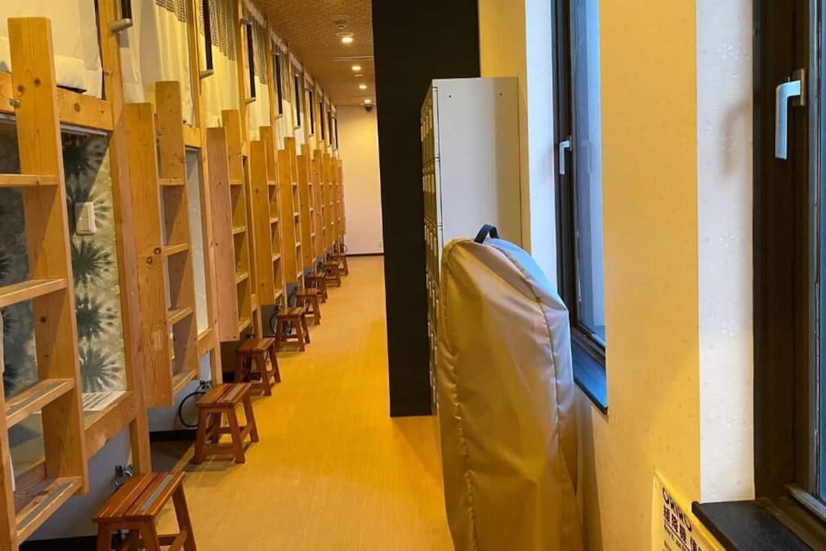 A corridor with wooden benches, a covered area, and a window.