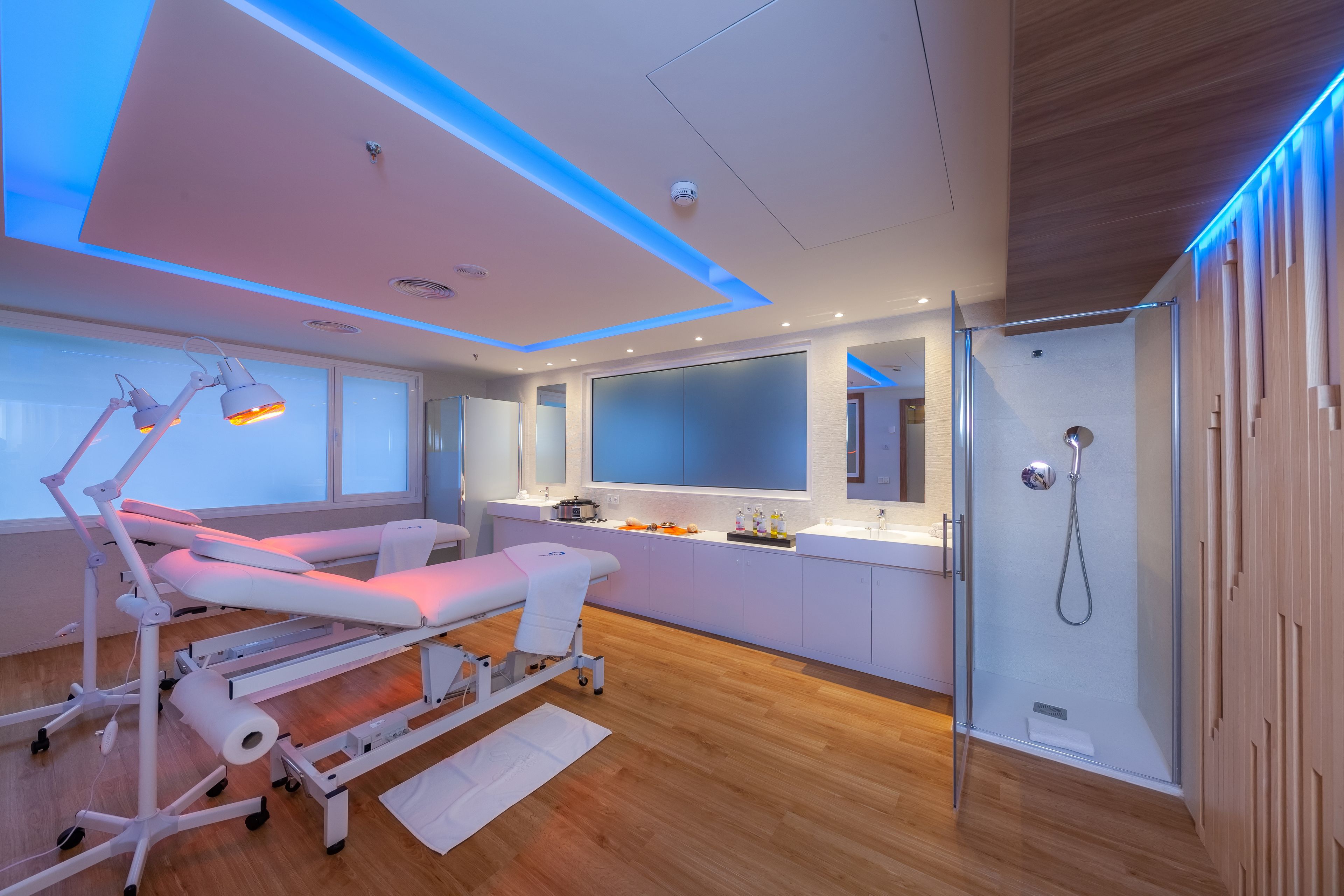 Un moderno centro médico con camillas de exploración, un ventanal grande y una zona de ducha.