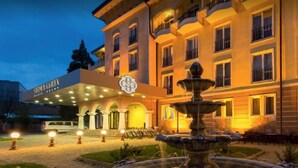 Ein Hotel mit einem Brunnen, einem überdachten Eingang und einem Schild mit der Aufschrift 'SHIMANO GARDEN'.