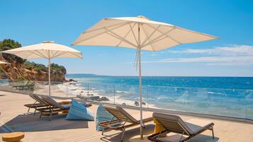 En la playa, camastros, sombrillas y vóleibol de playa