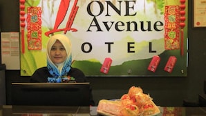 A reception desk at Putra ONE Avenue Hotel with a sign above displaying the hotel's name. - Putra One Avenue Hotel (Seri Kembangan)