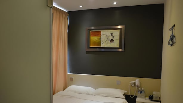 A hotel room with a bed, bedside table, and a painting on the wall. - Putra One Avenue Hotel (Seri Kembangan)