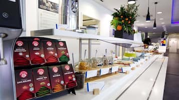 A breakfast buffet with labeled food items and a water dispenser.
