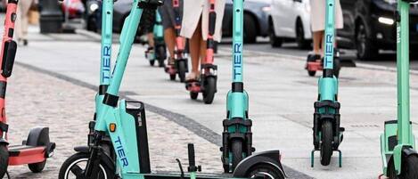 Une rangée de trottinettes électriques est garée sur un trottoir.
