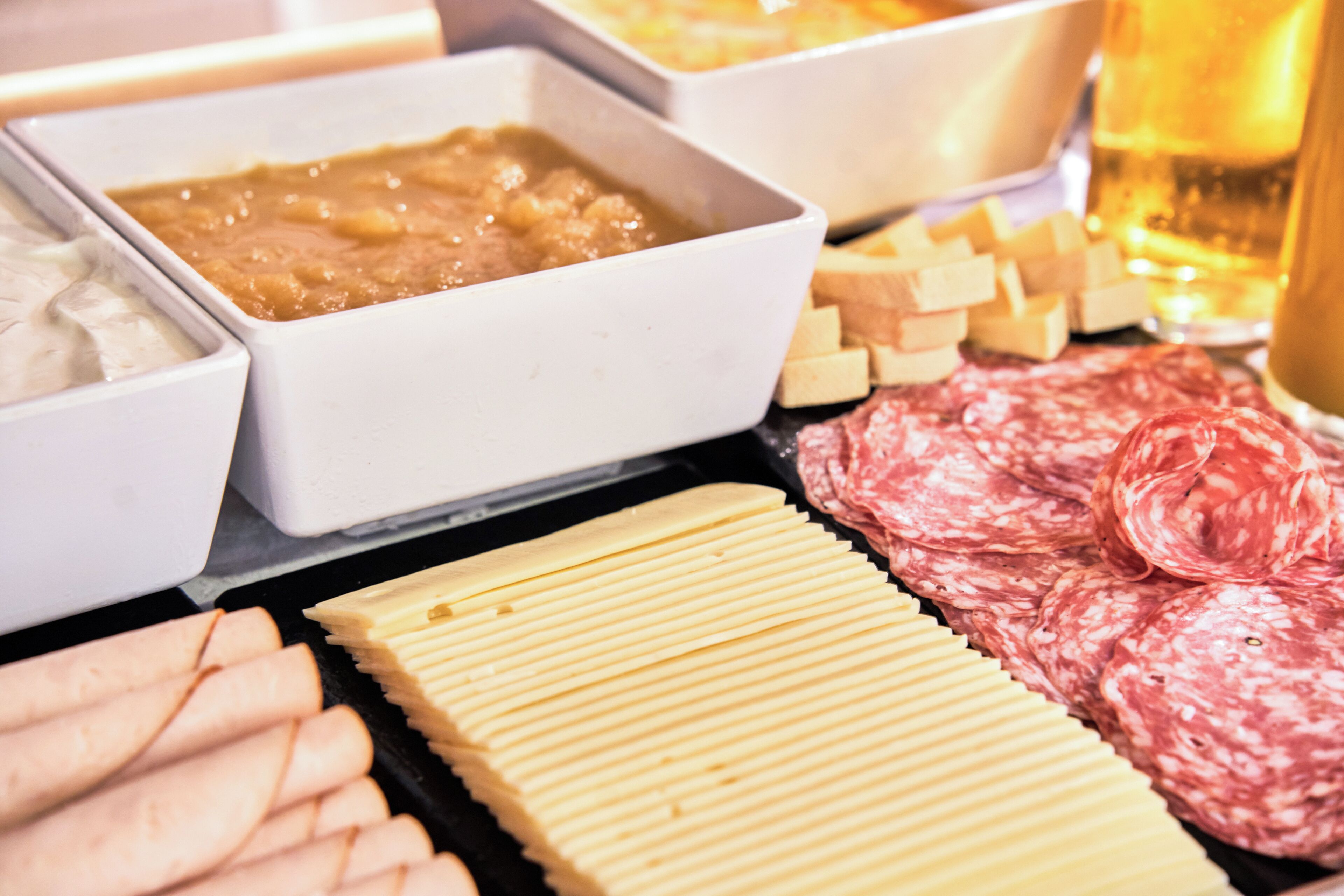 A variety of food items including sliced meats, cheeses, and dips.