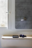 Une pièce avec une fenêtre, un stéthoscope fixé au mur et une étagère sur laquelle se trouvent un smartphone et des écouteurs.