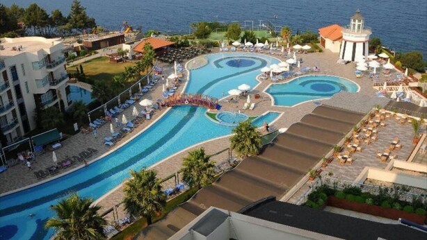 A resort with multiple swimming pools, sun loungers, and a view of the sea. - Sealight Resort Hotel (Kusadasi)