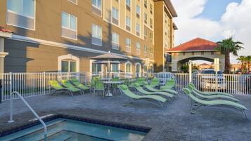 A hotel pool area with lounge chairs and a pool.