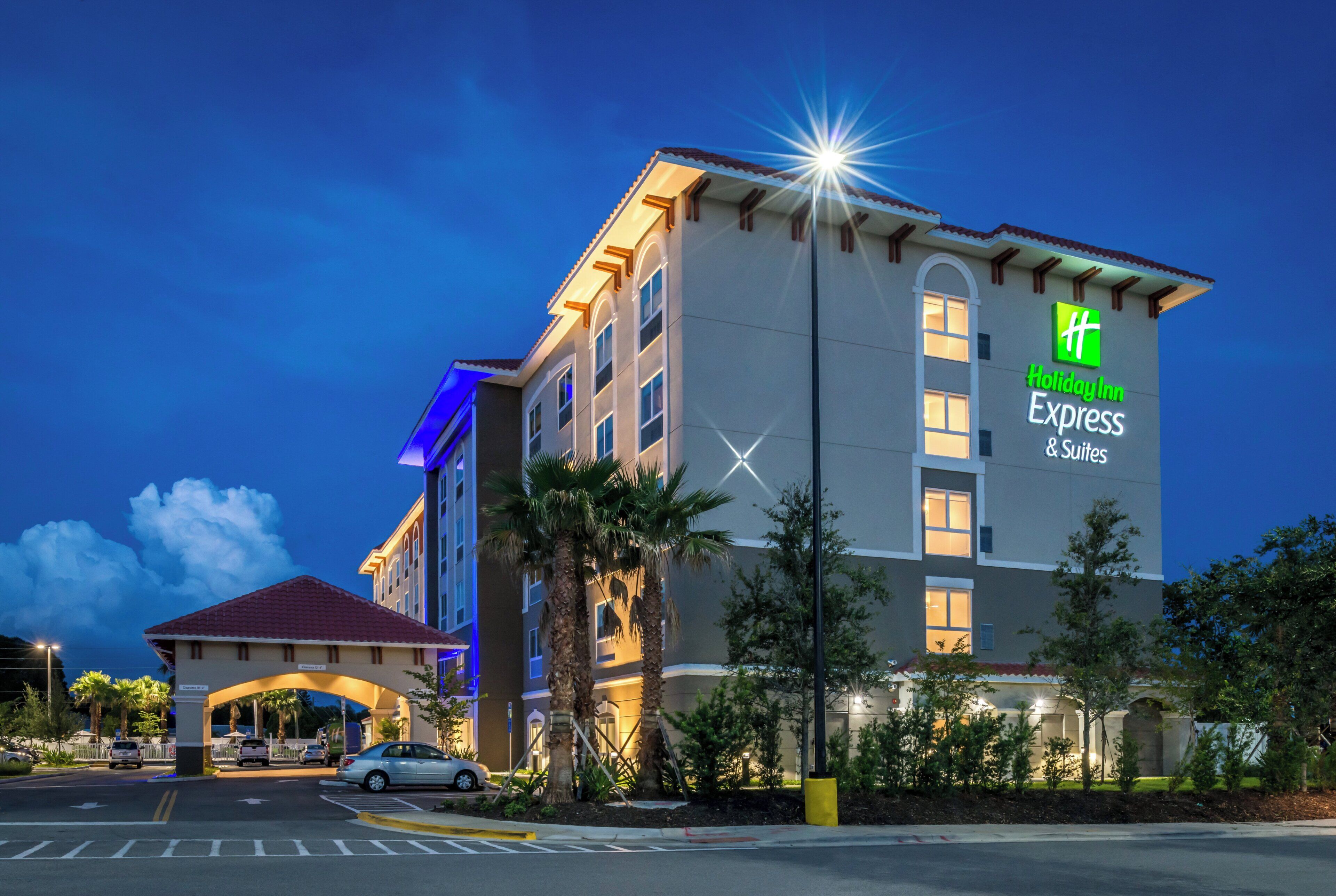 Un hotel Holiday Inn Express & Suites con un diseño moderno, que presenta un llamativo letrero de 'Holiday Inn Express & Suites' en el edificio.