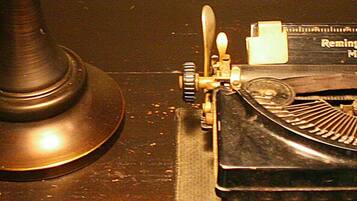 A vintage Remington typewriter with a metal base and a paper tray.