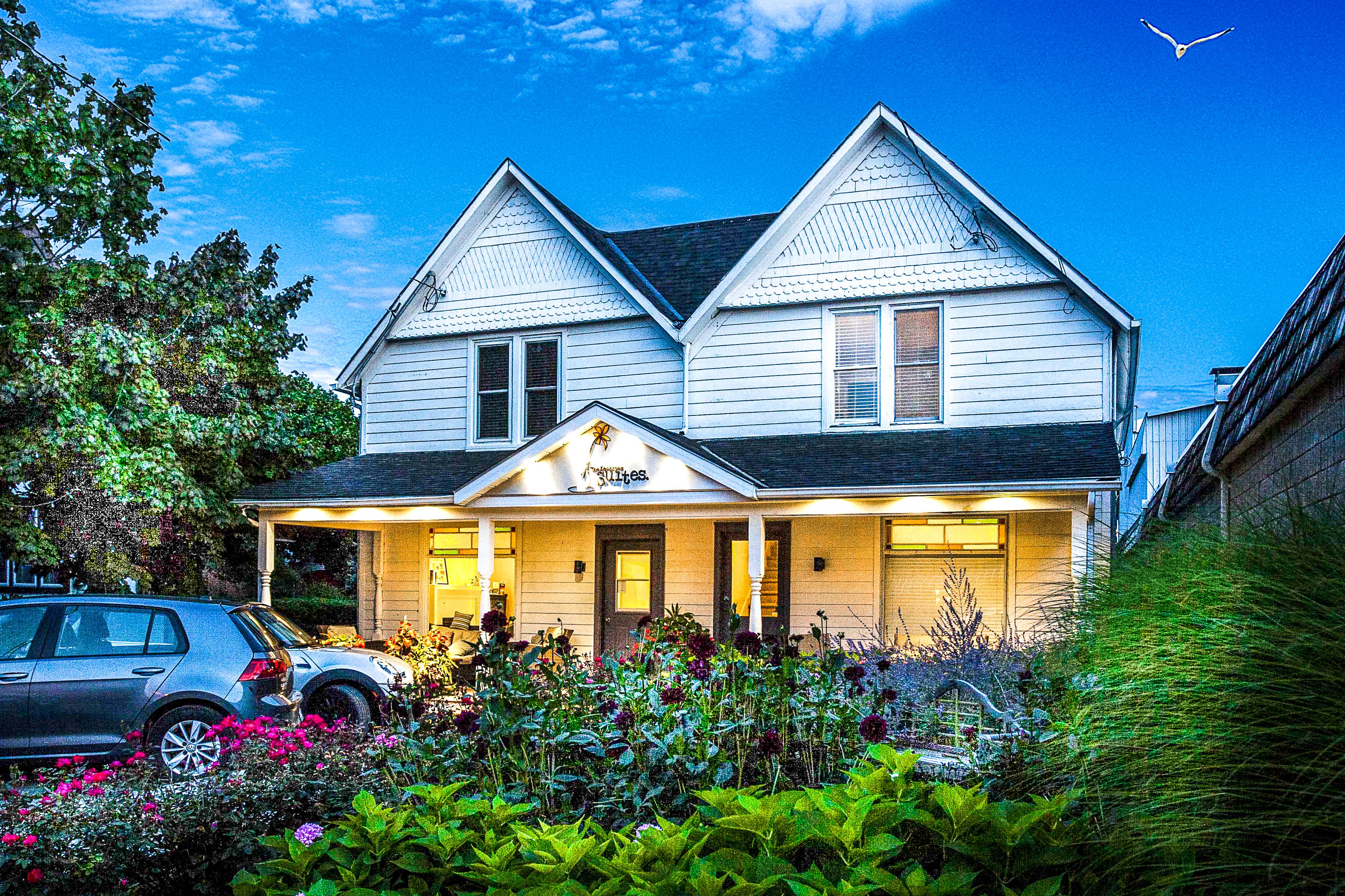Une maison à deux étages avec un porche et une enseigne sur laquelle on peut lire « Confiseries ».