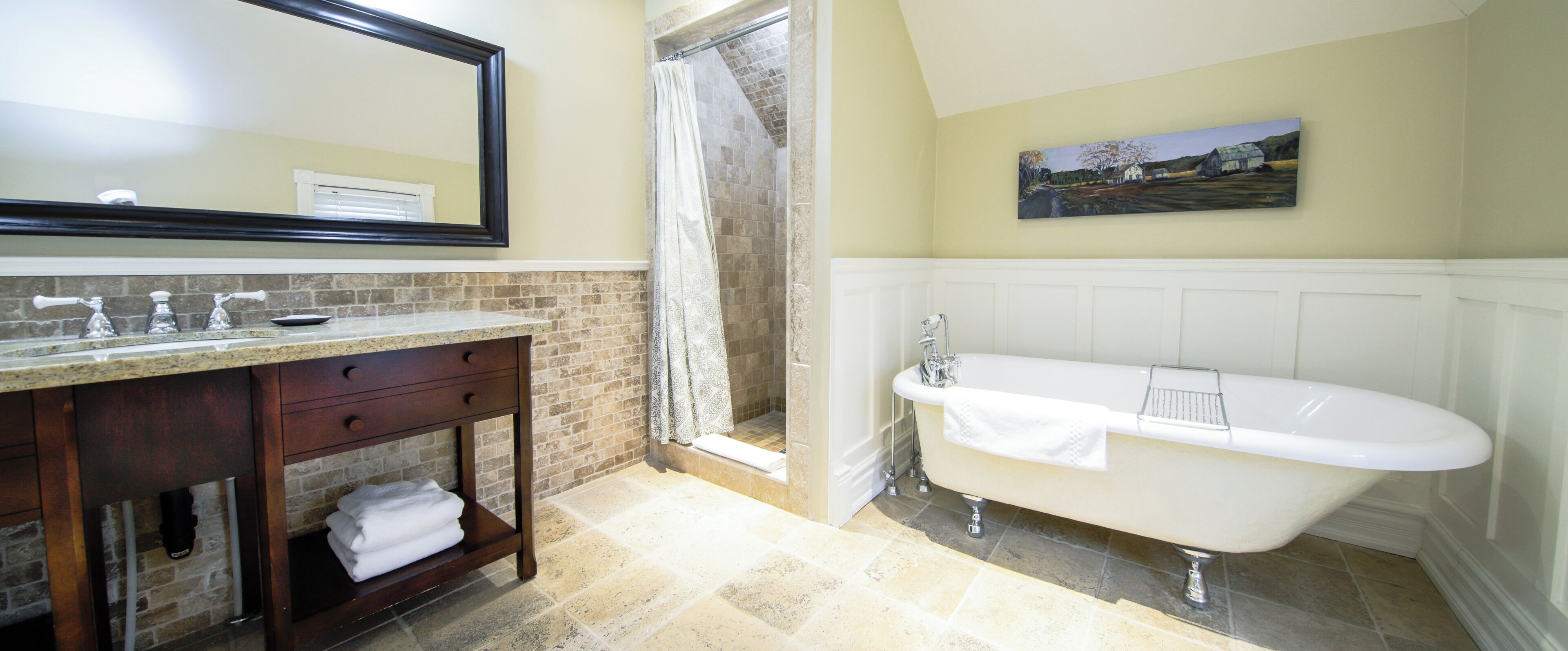 Une salle de bain avec une baignoire, une douche, un lavabo avec un miroir et un porte-serviettes.