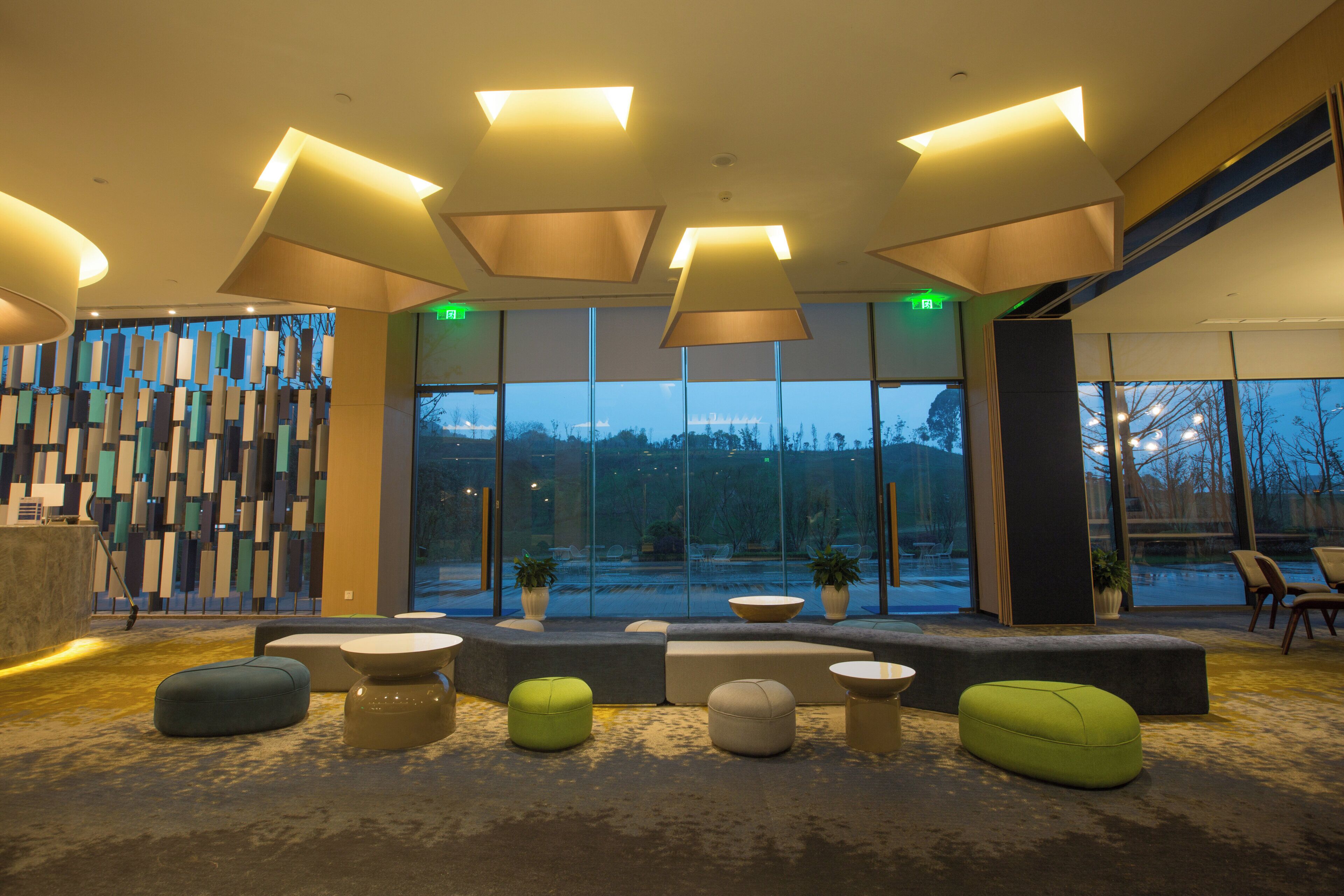 A modern lobby with a seating area, large windows, and a decorative wall.
