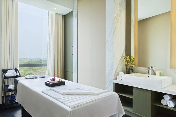 A hotel room with a bed, a bathroom with a sink and mirror, and a view of the outdoors.