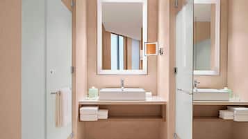 Un baño moderno con un espejo grande, un lavabo y una zona de ducha.