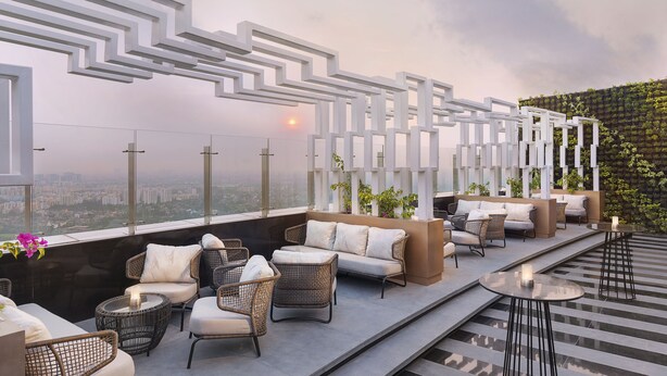A rooftop terrace with wicker furniture, a view of the city, and a decorative white structure. - The Westin Kolkata Rajarhat (Barasat)