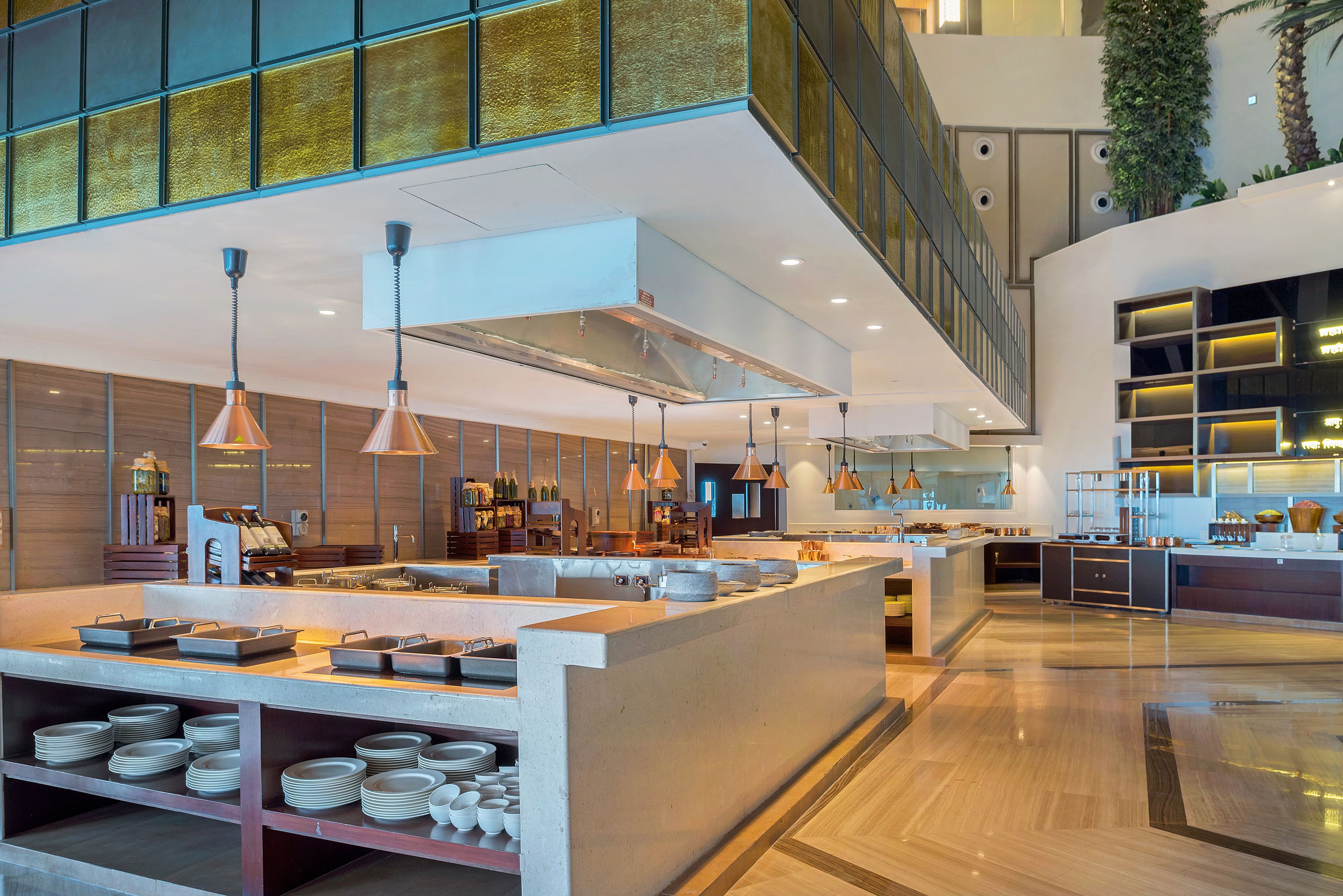 Una cocina moderna con una isla central, iluminación colgante y una variedad de electrodomésticos.