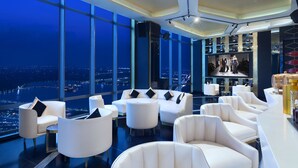 A modern lounge with white furniture, large windows, and a city view. - The Westin Kolkata Rajarhat (Barasat)