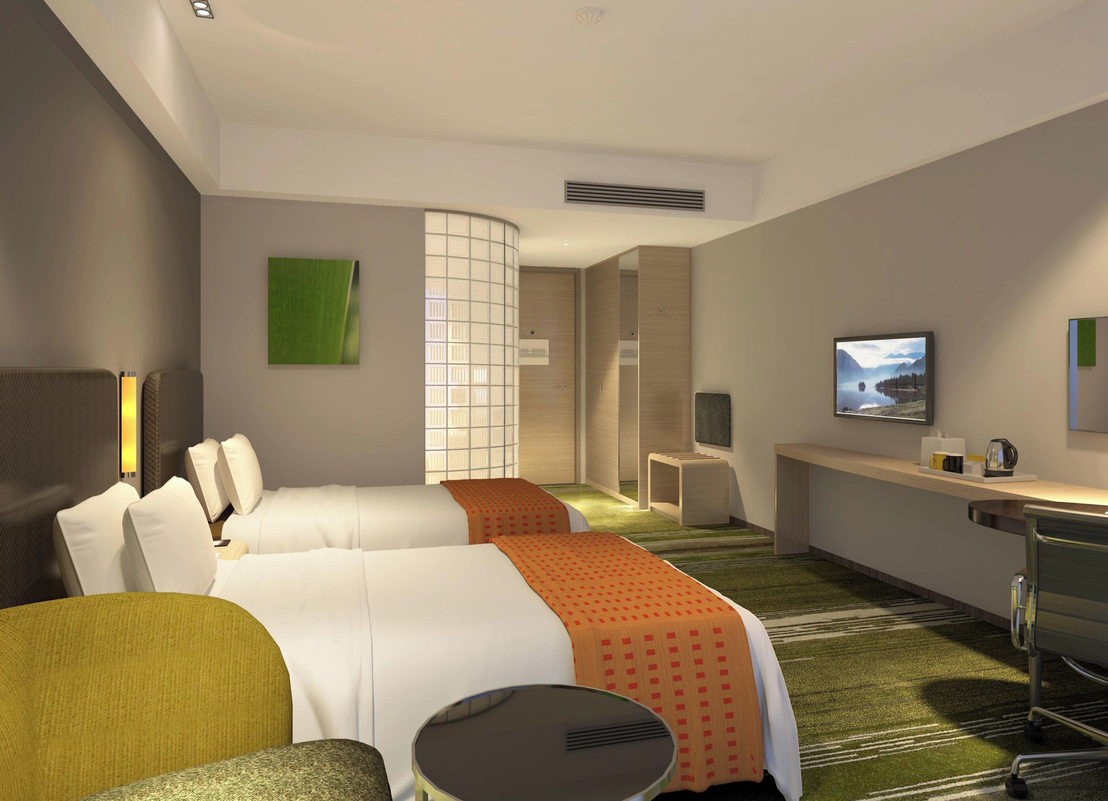 A hotel room with two beds, a desk, a chair, a television, and a view of a lake.