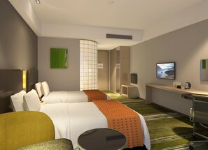Une chambre d’hôtel moderne équipée d’un lit, d’un bureau, d’une chaise et d’un téléviseur.