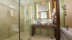 Une salle de bain moderne avec une douche à parois de verre, un lavabo avec un miroir et des toilettes.