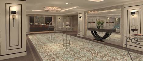 A spacious hotel lobby with a patterned carpet, a reception desk, and a dining area with a round table and chairs.