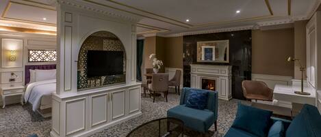 A luxurious living room with a fireplace, comfortable seating, and a television.