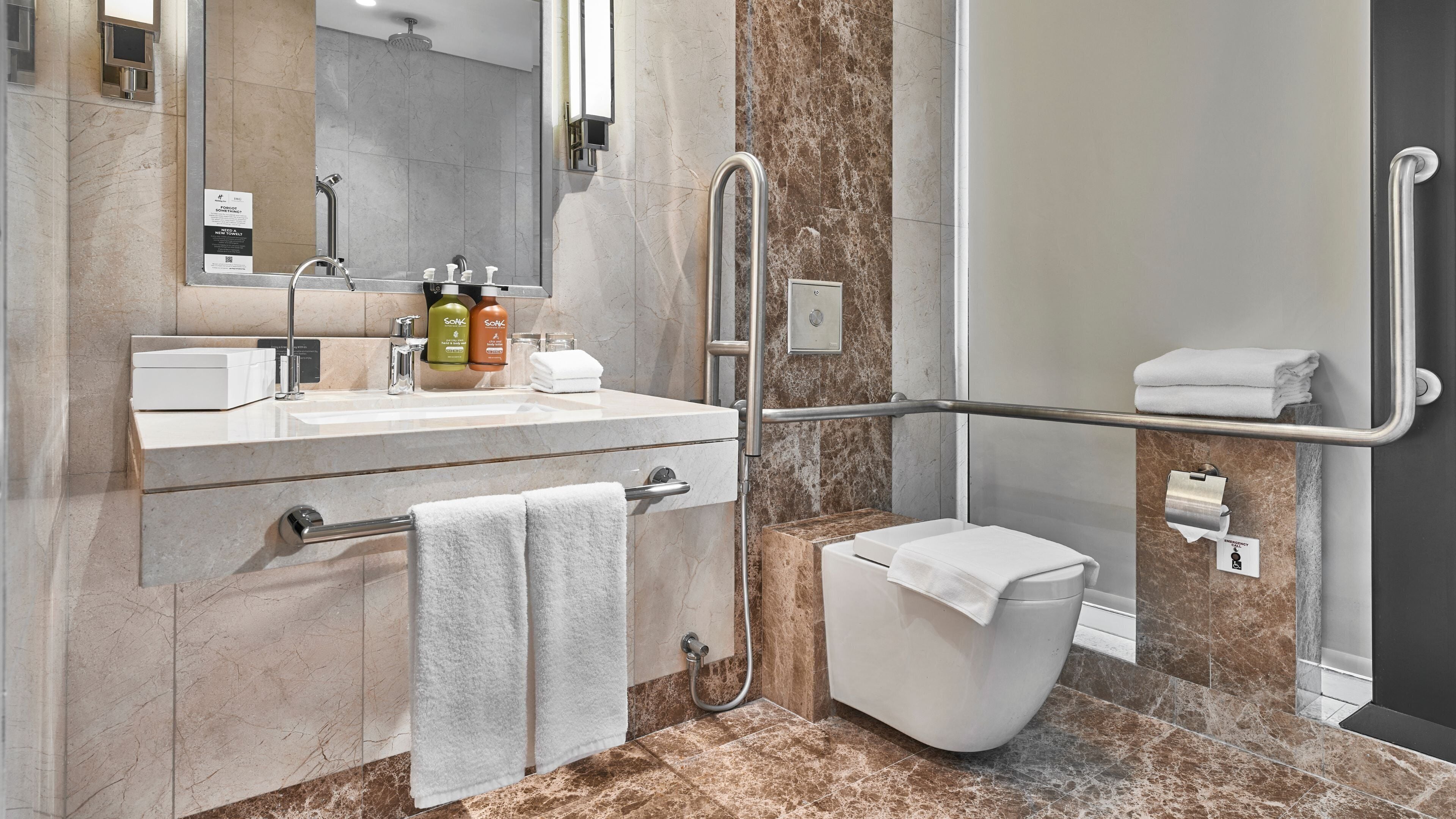 A modern bathroom with a shower, toilet, and sink.