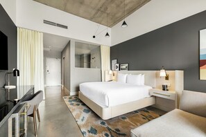A modern hotel room with a large bed, bedside tables, a desk, a chair, a shower area, and a view of the hallway. - Mountain Shadows Resort Scottsdale (Paradise Valley)