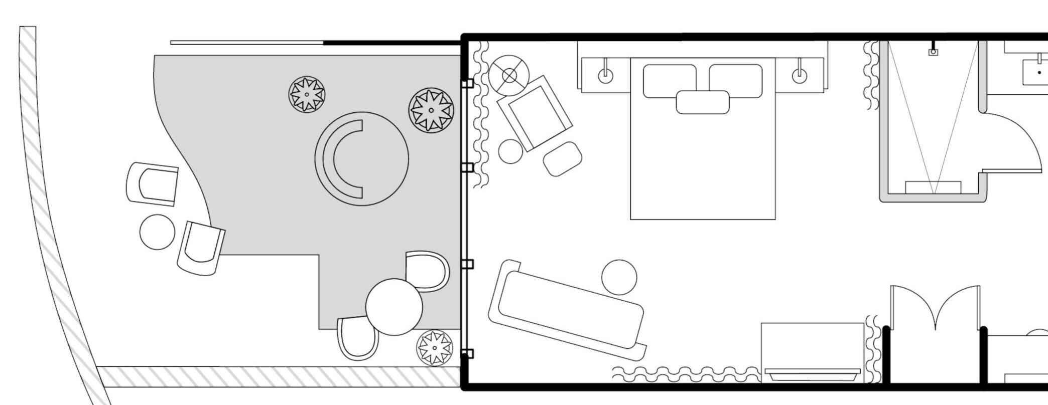 Layout de quarto de hotel com cama, área de estar e banheiro.