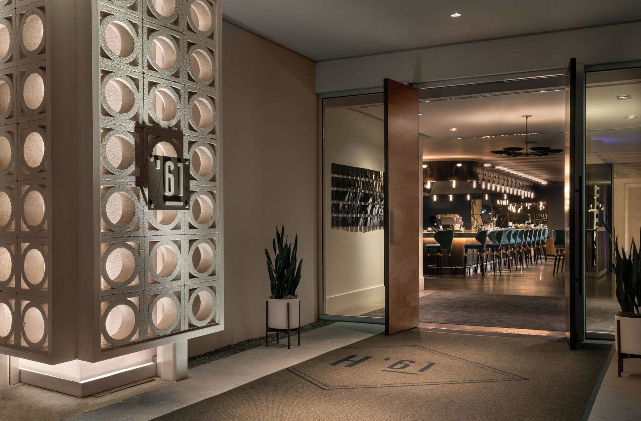 L’entrée de l’hôtel présente un design moderne, avec un espace d’accueil et un bar/salon doté de sièges.