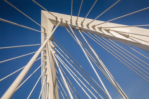 A close-up of a bridge's cable structure against a clear blue sky.
