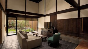 Un interior moderno con un sofá, una silla, un televisor y un mueble de madera.