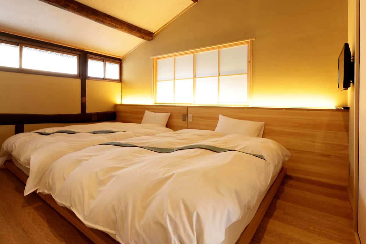 Ein Schlafzimmer mit einem großen Bett, einem Holzkopfteil und einem Fenster mit Blick.