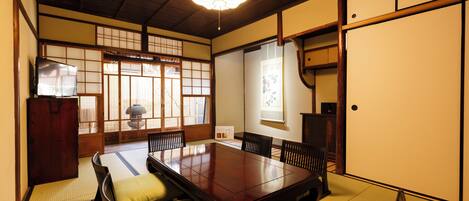 Una tradizionale stanza in stile giapponese con pavimento in tatami, un tavolino basso e paraventi shoji.