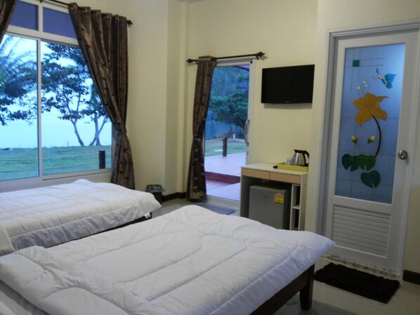 A hotel room with two beds, a small kitchenette, a TV, and a view of the sea. - Lomtalay Resort Trat (Laem Ngop)