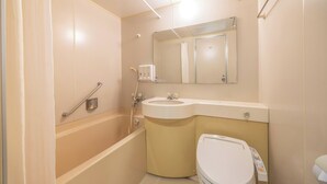 A bathroom with a bathtub, a sink, a toilet, and a mirror. - Hirosaki Plaza Hotel (Hirosaki)