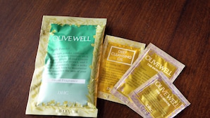 Three packages of Olive Well bath products on a wooden surface. - Hirosaki Plaza Hotel (Hirosaki)