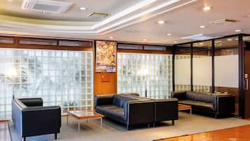 A modern lobby with leather sofas, a coffee table, and a large poster on the wall.