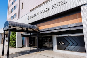 Het uiterlijk van Hotel Hiroaki Plaza, met een overdekte ingang en een naambord.