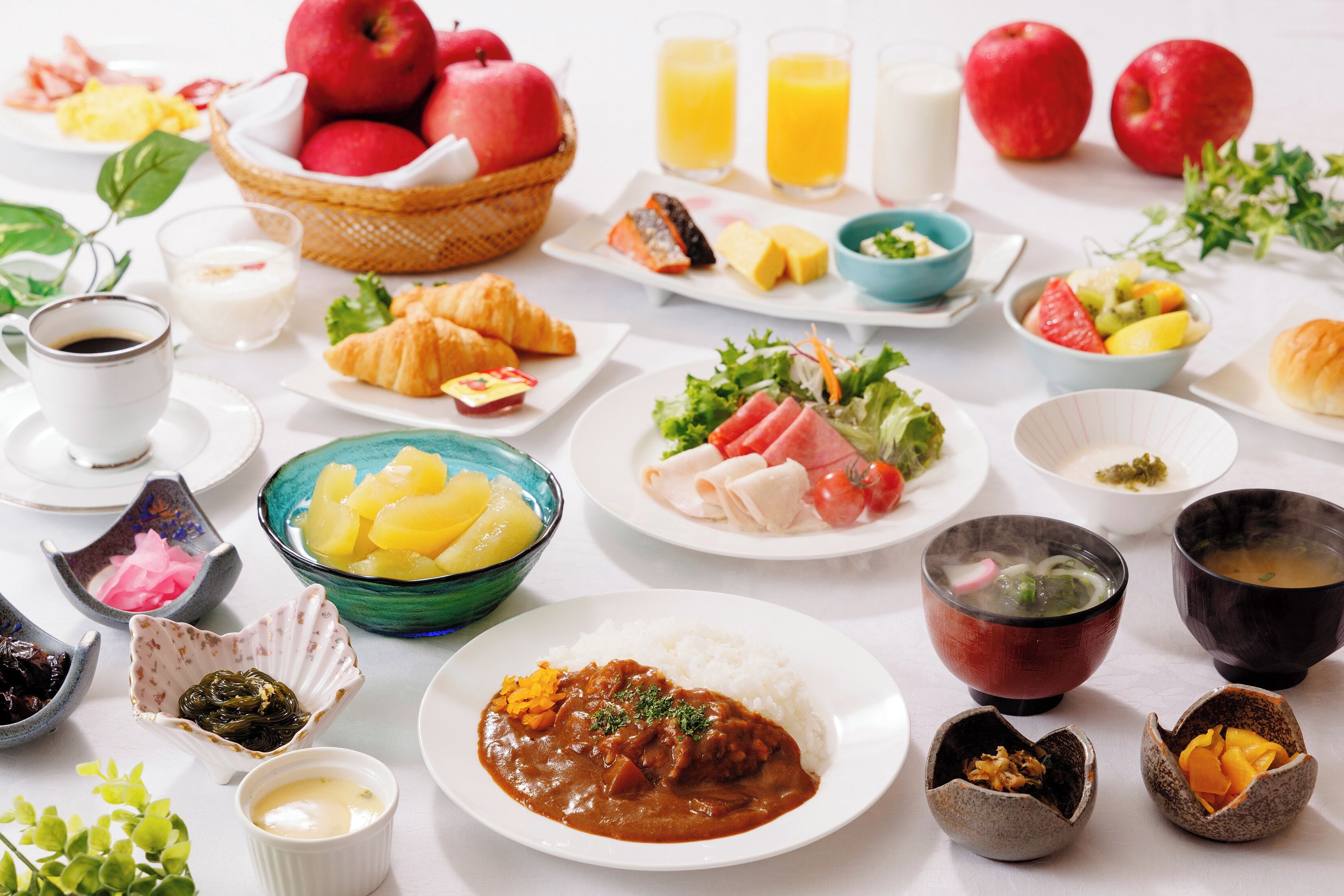 A breakfast spread with various dishes, fruits, and beverages.